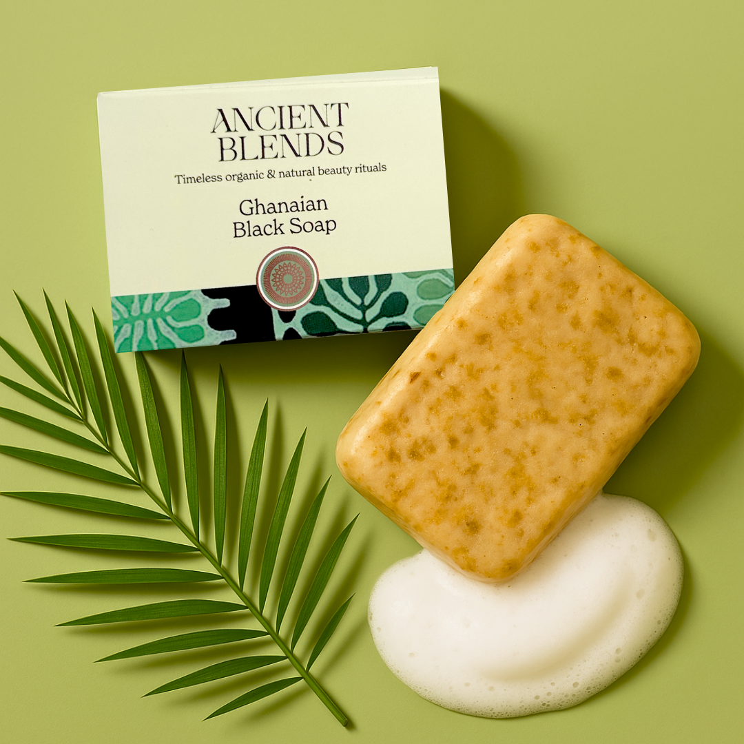 Packaged Ghanaian black soap with a green label featuring leaf patterns and product name details.